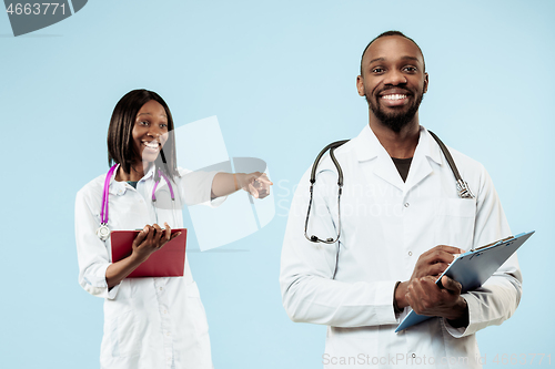 Image of The female and male happy afro american doctors on blue background