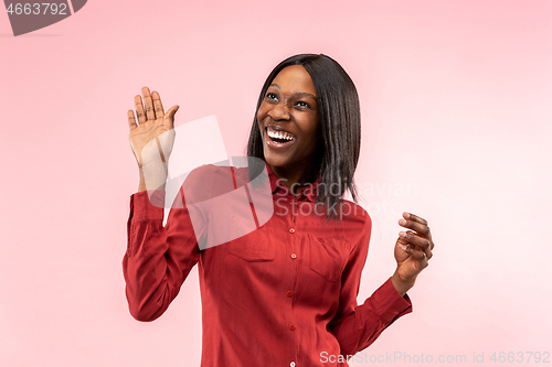 Image of The happy african woman standing and smiling against red background.