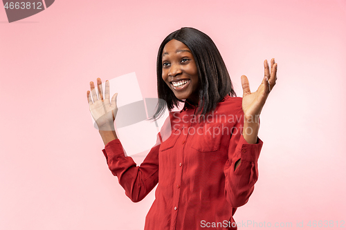 Image of The happy african woman standing and smiling against red background.