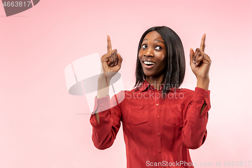 Image of The happy african woman standing and smiling against red background.