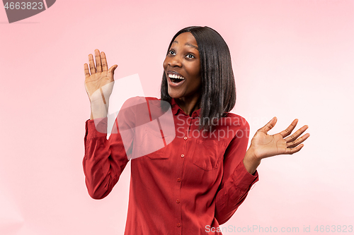 Image of The happy african woman standing and smiling against red background.