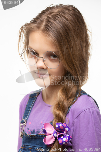 Image of Portrait of a girl of eleven in round glasses and a long braid