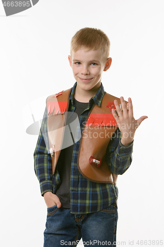 Image of Portrait of a boy in a cowboys vest and raising his hand