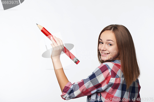 Image of Teen girl writing with big pencil on copy space