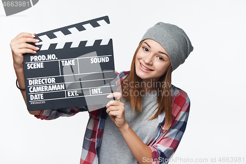 Image of Smiling teen girl holding clap board