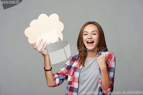 Image of Smiling girl holding thinking bubble looking at camera