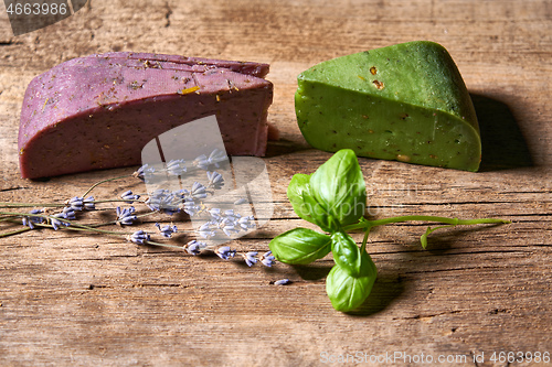 Image of Gourmet lavender and pesto cheeses on rough wooden planks