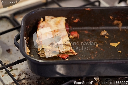 Image of Lasagna leftover in a dirty kitchen