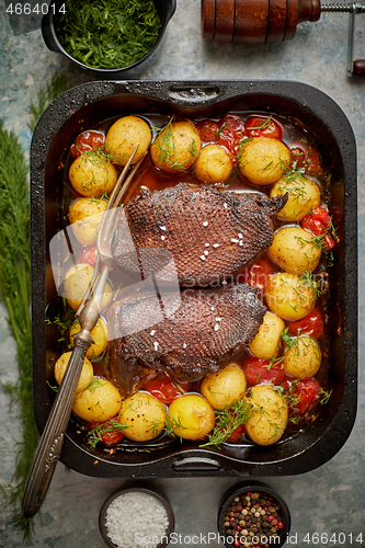 Image of Delicious roasted goose breast served with vegetables, potatoes.