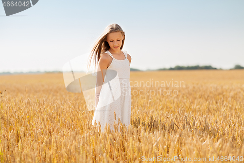Image of smiling young girl on cereal field in summer