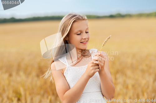 Image of girl with spikelet of wheat on cereal field