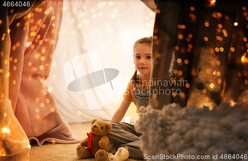 Image of little girl with toys in kids tent at home