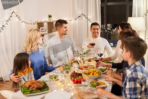 Image of happy family having dinner party at home