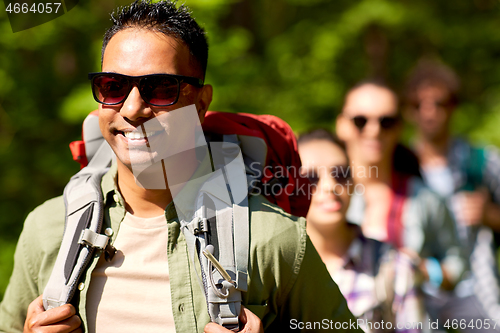 Image of group of friends with backpacks hiking in forest