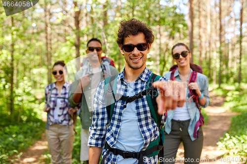 Image of friends with backpacks on hike in forest