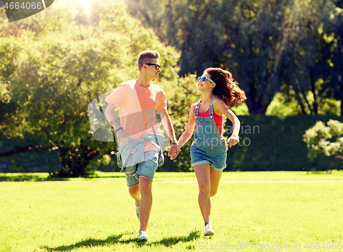 Image of happy teenage couple running at summer park