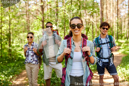 Image of friends with backpacks on hike in forest