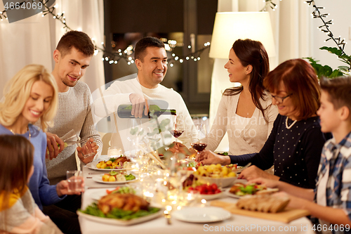 Image of happy family having dinner party at home