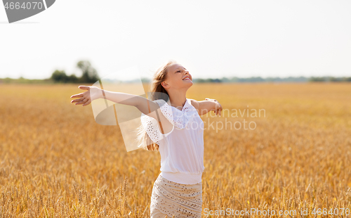 Image of smiling young girl on cereal field in summer