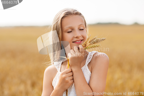 Image of girl with spikelet of wheat on cereal field