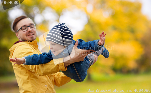 Image of father with son playing and having fun in autumn