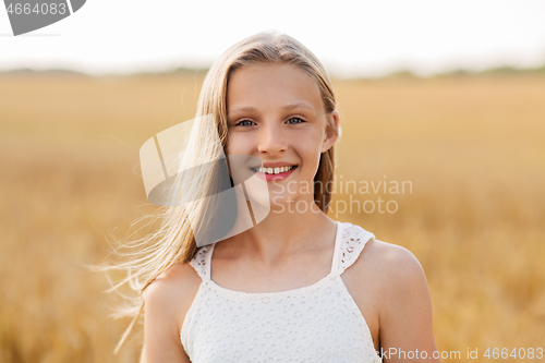 Image of smiling young girl on cereal field in summer
