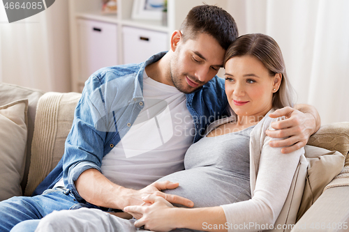 Image of man hugging pregnant woman at home