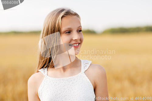 Image of smiling young girl on cereal field in summer