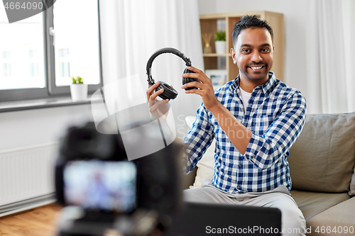 Image of male blogger with headphones videoblogging at home