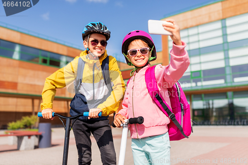 Image of happy school kids with scooters taking selfie