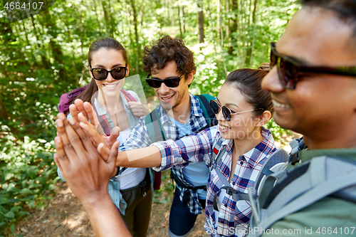 Image of friends with backpacks hiking and making high five