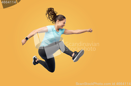 Image of happy fit young woman jumping in air