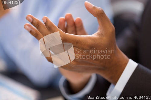 Image of hands of businessman applauding at conference