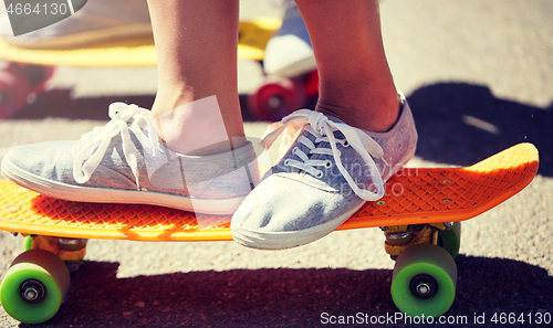 Image of close up of feet riding skateboards on city street