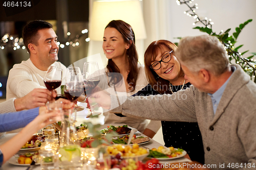 Image of happy family having dinner party at home
