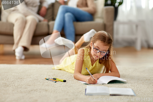 Image of student girl writing to notebook at home