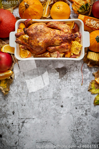 Image of Festive chicken baked by Thanksgiving on white owen plate and a harvest of seasonal vegetables