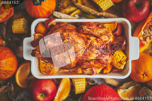 Image of Festive chicken baked by Thanksgiving on white owen plate and a harvest of seasonal vegetables