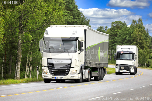 Image of Two White Freight Trucks on Highway