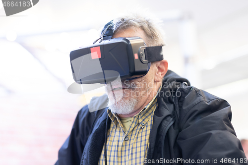 Image of Senior man wearing virtual reality headset glasses. Virtual reality presentation