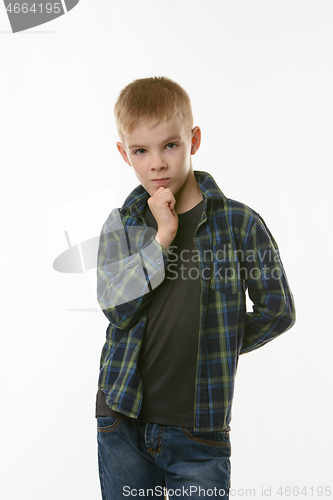 Image of Portrait of a pensive boy in a plaid shirt on a white background