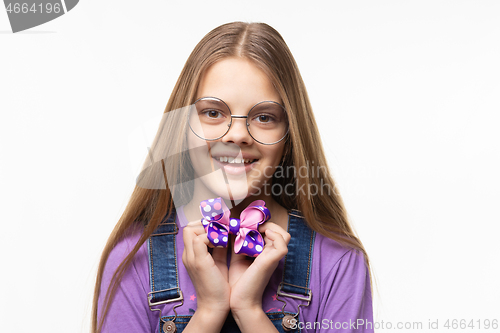 Image of Cheerful girl in glasses holds a beautiful blue bow in her hands