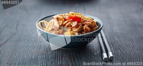 Image of fried noodles and vegetables with hot chicken sauce
