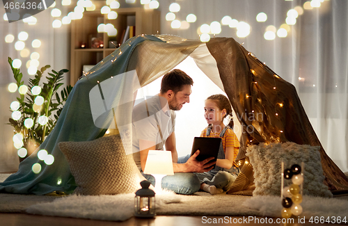 Image of family with tablet pc in kids tent at home