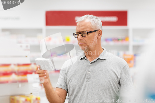 Image of senior male customer with drug at pharmacy