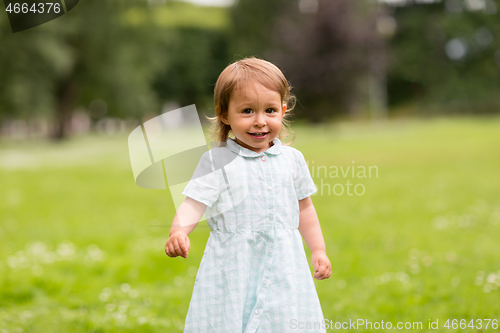 Image of happy little baby girl at park in summer