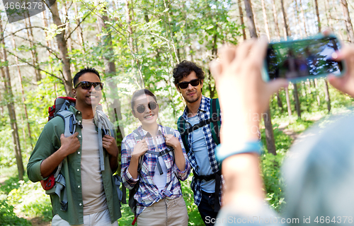 Image of friends with backpacks being photographed on hike