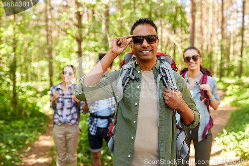 Image of friends with backpacks on hike in forest