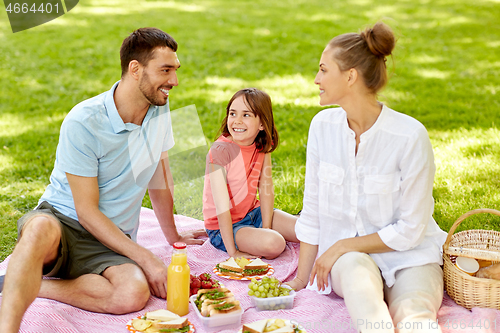 Image of happy family having picnic at summer park