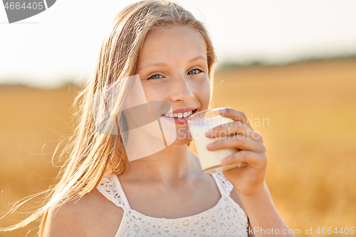 Image of girl drinking milk from glass on cereal field